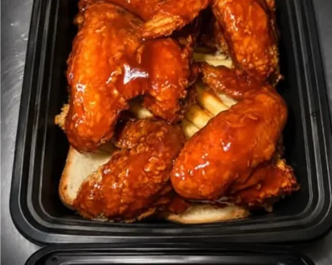 Sauced whole wings served over fries from Taste My City BBQ